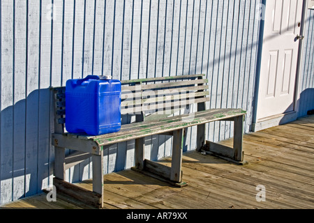 Blaue Kunststoff-Kanister auf einer Bank. Stockfoto