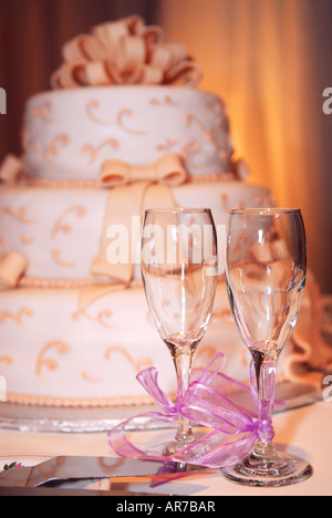 Drei abgestufte Hochzeitstorte und Champagner-Gläser auf einem Tisch Stockfoto