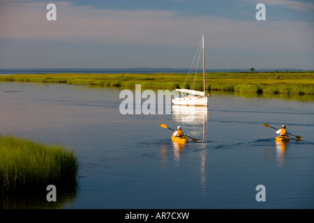 Kanuten paddeln vorbei an einem Segelboot vor Anker zwischen Great Island und der Küste in Old Lyme in Connecticut River Stockfoto