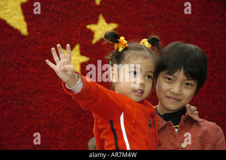 Kinder vor einer chinesischen Nationalflagge aus Blumen zum Gedenken an nationalen Tag Chongqing China gemacht Stockfoto