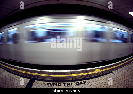 District Line u-Bahn vorbei an einer Plattform in London. Fotografiert mit einem Fisheye-Objektiv. Stockfoto