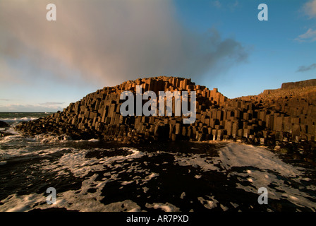 Stürmischen Himmel über der sechseckigen Form Basaltsäulen an der Giant es Causeway, County Antrim, Nordirland Stockfoto