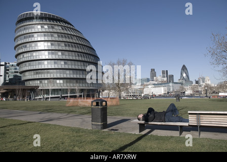 London Assembly mit Obdachlosen im Vordergrund und St Mary Axe Gherkin im Hintergrund Stockfoto