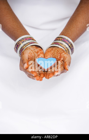 Inderin mit Henna Händen hält Herz geformten Schale. Indien Stockfoto