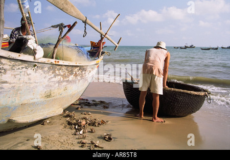 Mann mit Fischerboot am Strand Stockfoto