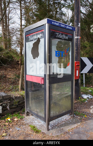 Geschändeter modernen ländlichen Telefonzelle mit Loch durch zerbrochenes Glasfenster Conwy North Wales UK Stockfoto