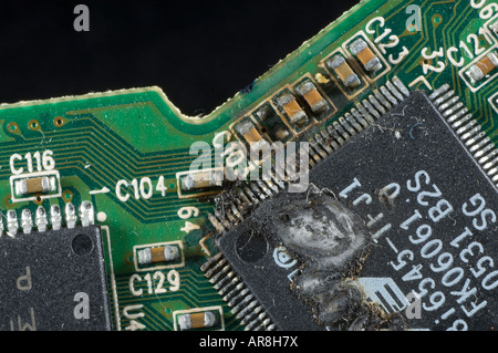 Verbrannte integrierte Schaltung Controller auf einem elektronischen Brett durch einen Zuschlag Stockfoto