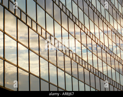 Sonnendurchflutete Wolken und blauer Himmel spiegeln sich im Glas Fenster Fassade des modernen Gebäudes im Frankfurter Messe Messegelände, Deutschland. Stockfoto