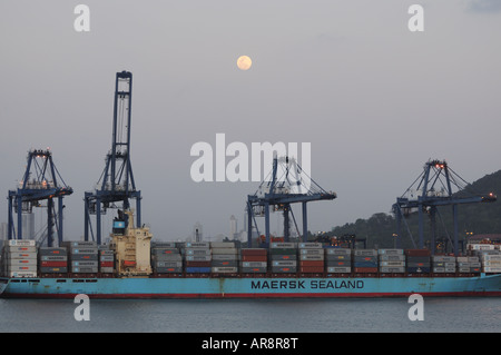 Auf der Pazifik Seite des Panama-Kanals steigt der Mond über die hohen Kräne, die Be- und Entladen von Fracht. Stockfoto