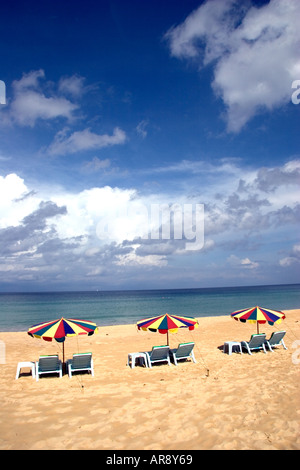 Drei Sonnenschirme öffnete sich auf einem einsamen Karon Strand an der Westküste von Phuket an einem perfekten sonnigen Tag mit weißen Wolken Stockfoto