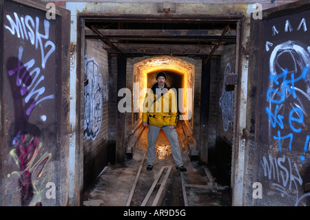 Mann, der in den Tunnel von einer verlassenen Fabrik Steinofen mit Graffiti an Türen Don Valley Ziegelei Toronto Stockfoto