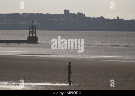 Statue und Leuchtturm am Strand von Crosby, Merseyside, UK Stockfoto