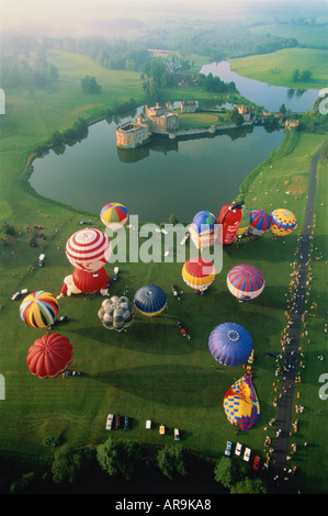 Luftaufnahme von Heißluft Ballons starten nehmen aus über grüne Rasenflächen und See Kent UK Leeds Castle in Ferne Stockfoto