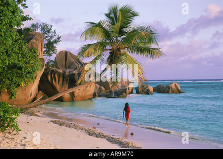 Frau allein auf der Insel La Digue auf den Seychellen im Abendlicht mit Granitfelsen und Sandstrand Stockfoto