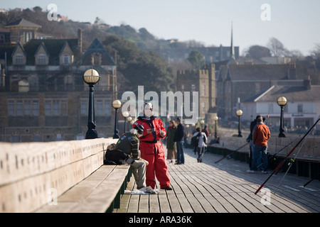 Männer Angeln in der Severn-Mündung vom historischen viktorianischen Pier in Clevedon, Somerset. Stockfoto