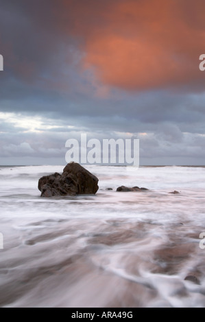 Rosa Wolke bei Sonnenaufgang Widemouth Bucht Cornwall UK Stockfoto