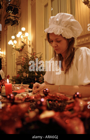 Junge Frau in traditioneller Tracht schmücken einen Schokoladenkuchen für Weihnachten Tschechien Stockfoto