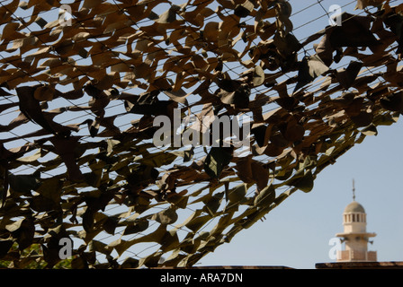 Perforierte getarnte militärische Saldierung mit Minarett der Moschee. Hebron, Westjordanland. Palästinensische Gebiete Stockfoto