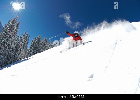 Ein Mann fährt durch Tiefschnee an einem sonnigen Tag in der Nähe von Telluride, Colorado Stockfoto