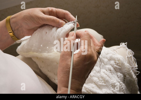 Womans Hände mit weißer Wolle stricken Stockfoto