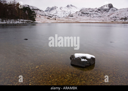 Blea Tarn mit saisonabhängige im Hintergrund mit Schnee bedeckt Stockfoto