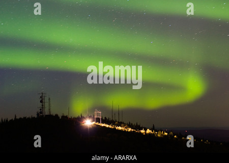 Wirbelnden Nordlicht über Hügel mit Antenne komplex und Carlights aus einzelnen geparkten Auto Stockfoto