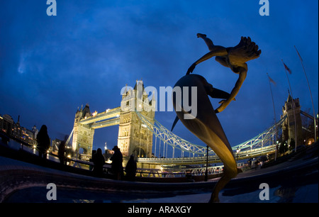 Die Tower Bridge und Statue Mädchen mit Delphin beleuchtet in der Nacht London England UK United Kingdom GB Großbritannien britische Inseln Stockfoto