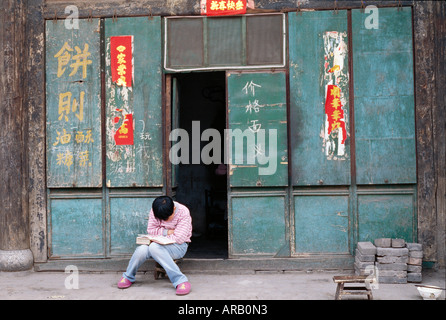 Person liest Buch im Freien, Pingyao, China Stockfoto