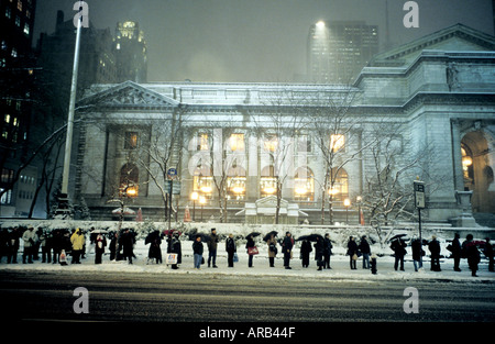 Eine Warteschlange an der Bushaltestelle im Schnee außerhalb der New York Public Library in New York USA Stockfoto