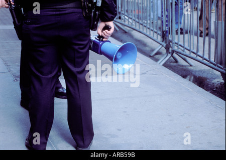 USA New York City Police Officers mit Megaphon außerhalb Barrikaden an einen Friedensmarsch und demonstration Stockfoto