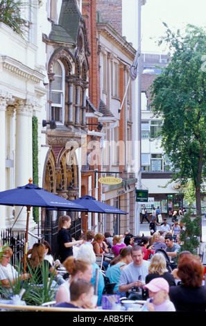 Ansicht des Cafés mit Leute sitzen draußen essen und trinken Stockfoto