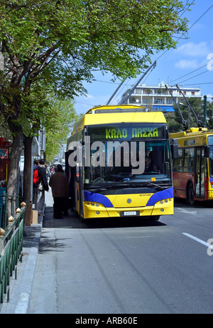 Kabel gelb öffentliche Athen Verkehrsmittel Straßenbahn Straße Menschen Busreisende Seite Tag Strom alten Kalo Pasxa Frohe Ostern blauen Baum Stockfoto