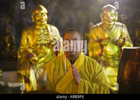 Buddhistischer Mönch Trommeln und Gesängen im inneren Tempels cave, Yangdang Berge, Wenzhou, Zhejiang Province, China Stockfoto