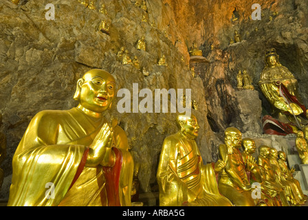 Goldenen Buddha-Statuen säumen Steinmauern der Tempel Höhle, Yangdang Berge, Wenzhou, Zhejiang Provinz, China Stockfoto