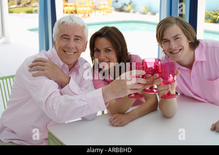 Drei Leute sitzen am Tisch mit Getränken Stockfoto