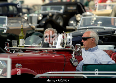 Zwei Männer genießen ein Glas Wein in ihrem Oldtimer Stockfoto