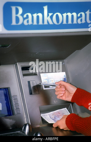 Hände halten Geld und EC-Karte am Geldautomaten in Schweden Stockfoto
