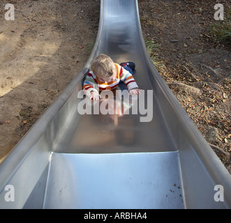 Baby rutscht die Rutsche auf dem Spielplatz Stockfoto