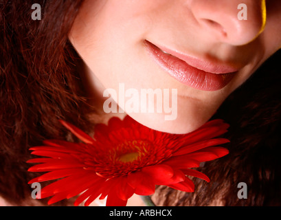 Makro-Bild von einem Mädchen Gesicht mit einer roten Blume Stockfoto