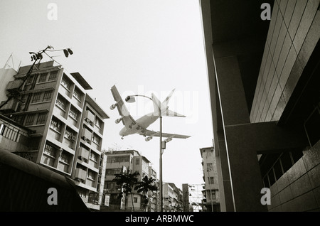 Flugzeug am alten Flughafen Kai Tak in Kowloon in Hong Kong in China in Südost-Asien Fernost ankommen. Transport Fernweh Aviation Sky Travel Stockfoto