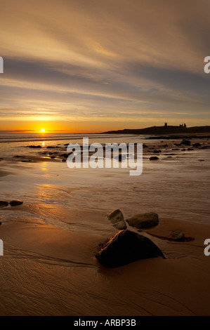 Morgendämmerung auf Embleton Strand mit Dunstanburgh Castle über Northumbria England UK Stockfoto