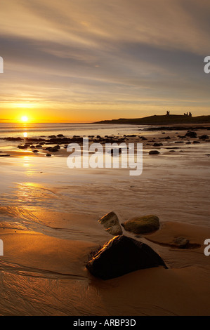 Morgendämmerung auf Embleton Strand mit Dunstanburgh Castle über Northumbria England UK Stockfoto