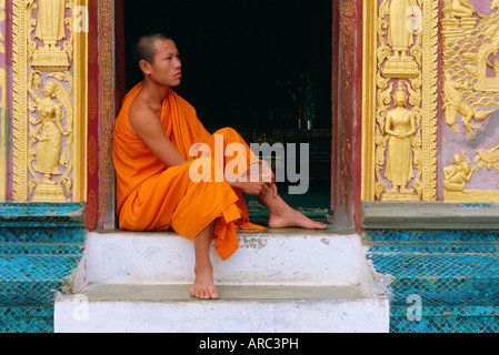 Mönch sitzt im Tempel Eingang, Wat Xieng Thong, Luang Prabang, Laos Stockfoto