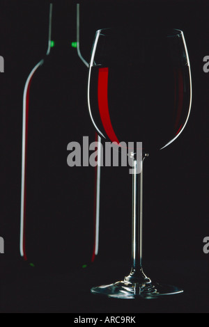 Studioaufnahme von hinten beleuchtete Glas und eine Flasche Rotwein Stockfoto