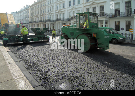 Straßenbauunternehmen auf der Ringway, einschließlich großer schwerer Walzen bei der Arbeit, verlegen neuer Asphaltflächen South Kensington West London England UK Stockfoto