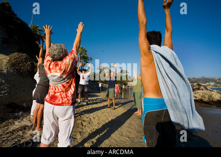 Mitglieder der einen Lachclub Yoga tun vorbereitenden Turnübungen am Meer in Laguna Beach Kalifornien erfüllen Stockfoto