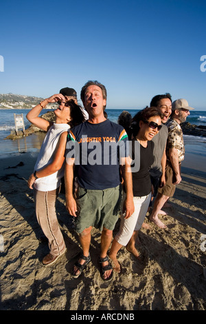 Der Wassertruppführer einen Lachclub Yoga setzt ein Zeichen für seine Mitglieder am Meer in Laguna Beach CA erfüllen Stockfoto