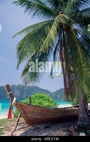 Holzboot unter Palmen am Strand Hin Phae Bucht, Ko Phi Phi Don, von der Insel Phuket, Thailand, Südostasien, Asien Stockfoto