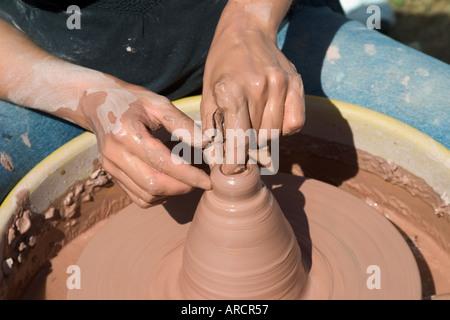 Junge Frau mache einen Becher auf der Töpferscheibe Stockfoto