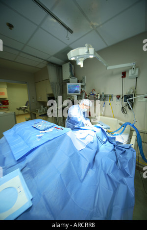 Eine weibliche chirurgische wohnhaft in der Intensivstation (ICU) einen recht subclavian zentralen Venenkatheter einlegen. Stockfoto